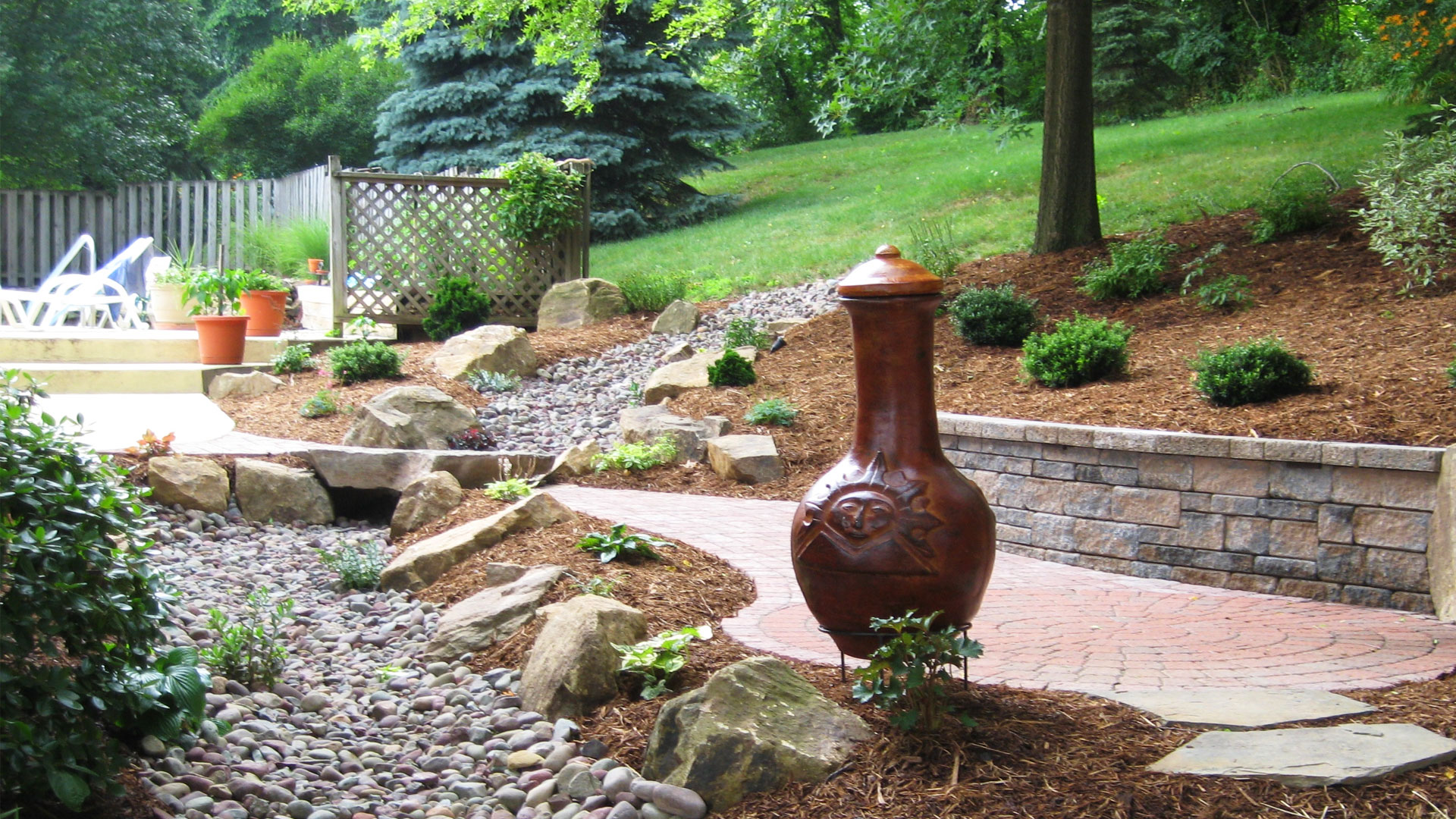 Patio with chiminea, natural stone, and hillside planting
