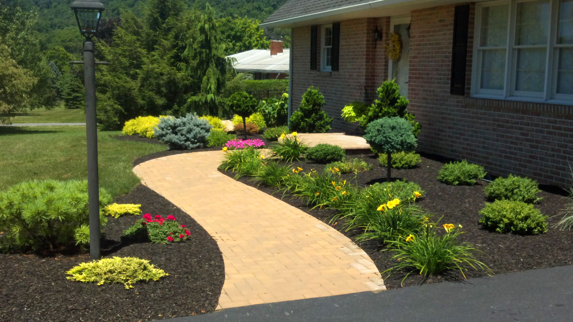 Curved brick walkway with colorful planting